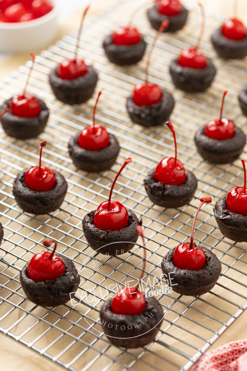 Mini chocolate brownies with cherries on a cooling rack