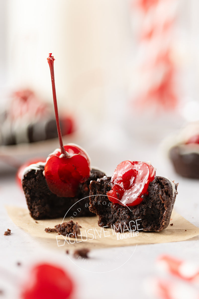 Chocolate mini brownie with cherries on parchment square with a blurred background