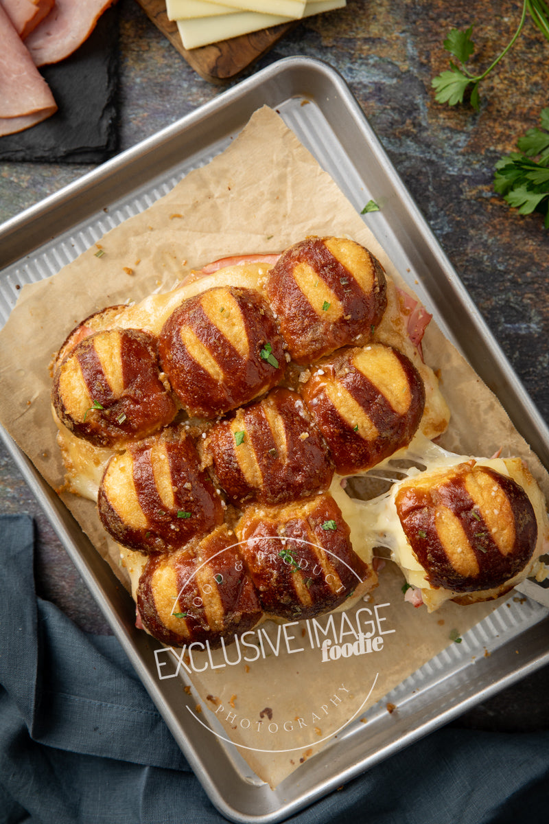 Baked sandwiches on a baking tray with cheese pull