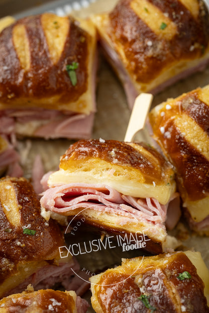 Ham and cheese sliders on a baking sheet with 'EXCLUSIVE IMAGE' watermark.